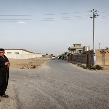Daratoo, Kurdistan, Northern Iraq. A man stands at a wide crossroad in the collective town of Daratoo. Photo: Leo Novel